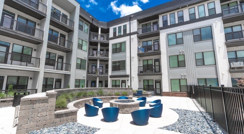 an outdoor area with a fountain in front of an apartment building