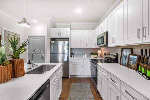 A modern kitchen with white cabinets and stainless steel appliances.