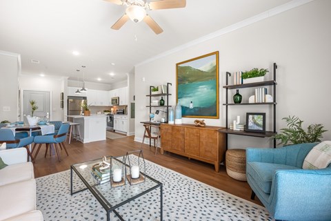 A living room with a blue sofa and a glass coffee table.