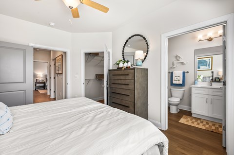 A bedroom with a large bed and a mirror on the wall.