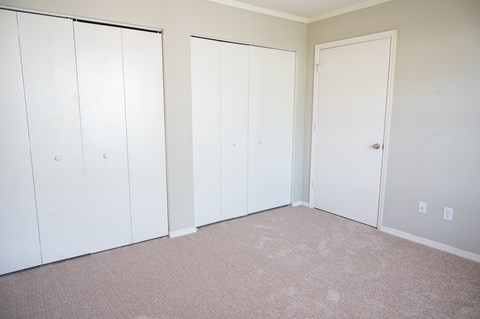 Spacious bedroom with plush carpeting in your home at Deerbrook Apartments in Wilmington, NC 28405