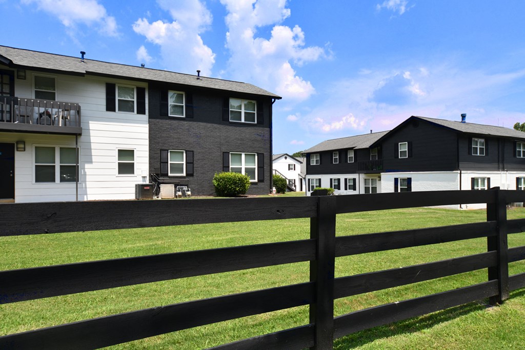 a black and white fence separates two rows of houses
