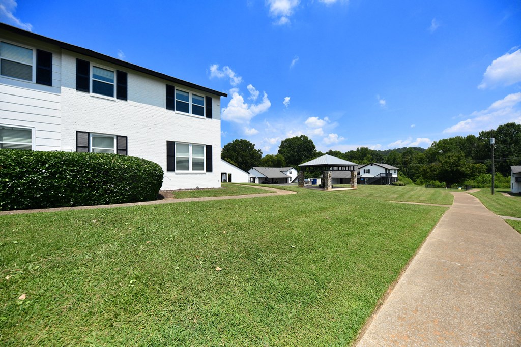 a large white building with a grassy area in front of it