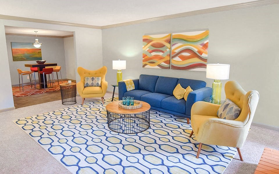 a living room with a blue couch and yellow chairs