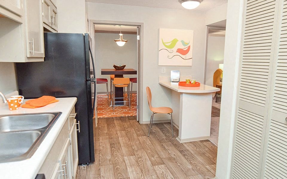 a kitchen and a dining room with a black refrigerator