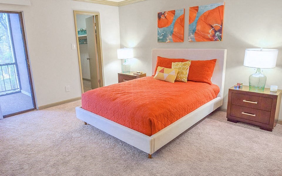 a bedroom with an orange bed and orange pillows