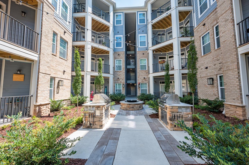 an outdoor courtyard with a fire pit in the middle of an apartment building