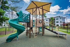 a playground with a green slide and a yellow pavilion