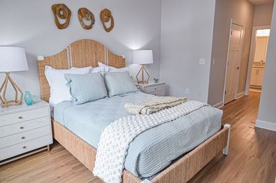 Beautiful bedroom with wood look plank flooring and walk-in closet at Hawthorne at Pine Forest in Oak Island, NC