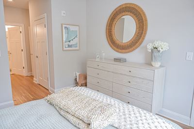 Beautiful bedroom with wood look plank flooring and walk-in closet at Hawthorne at Pine Forest in Oak Island, NC