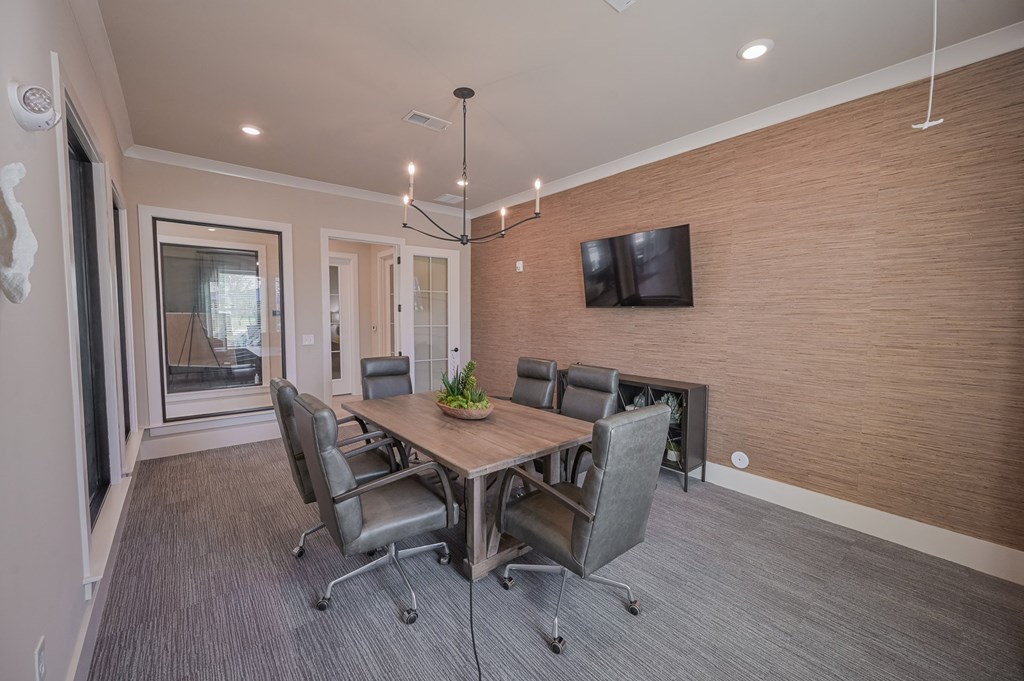 a dining room with a table and chairs and a tv on the wall