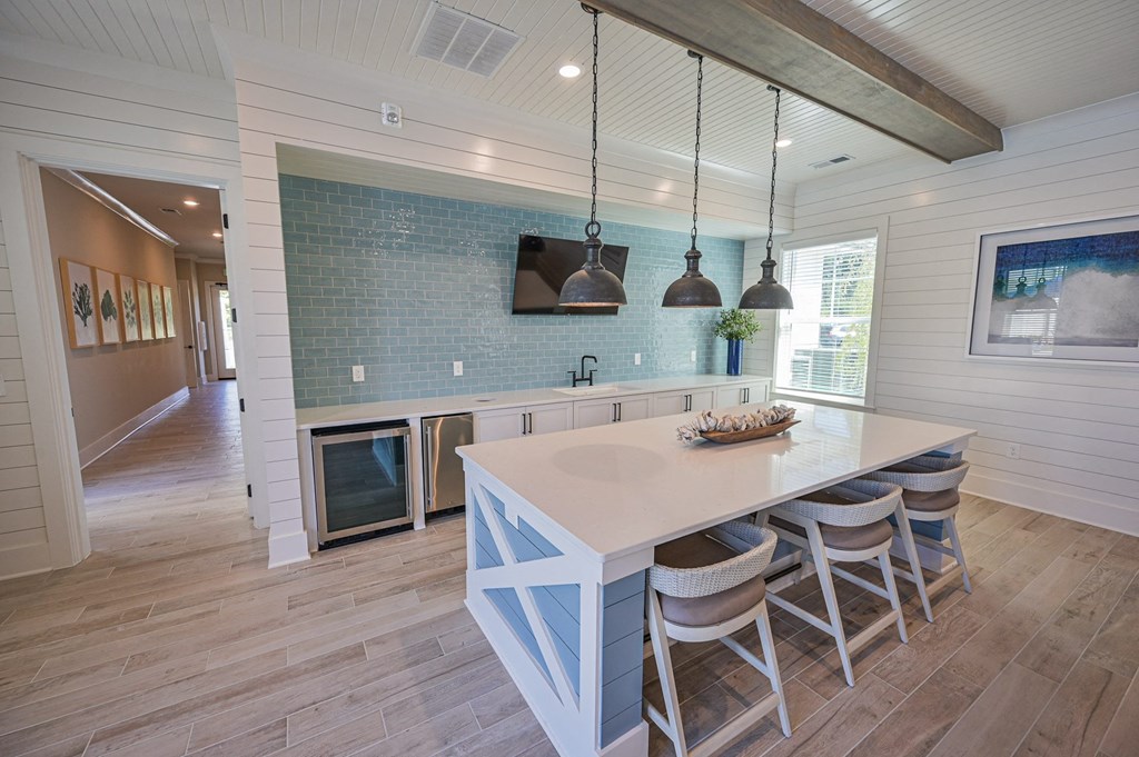 a kitchen with a large island and white chairs