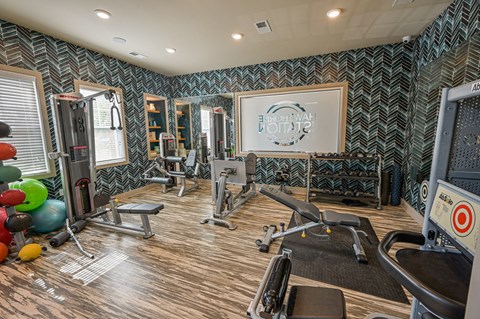 a gym with weights and cardio equipment and a sign on the wall