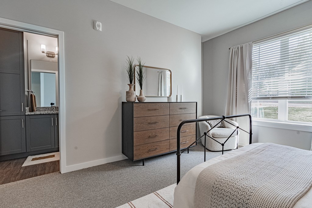 a bedroom with a bed and a dresser and a window