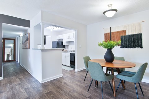 A dining room with a table and chairs.