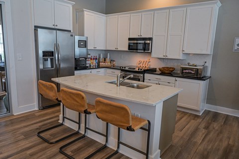 a kitchen with a center island and a stainless steel refrigerator