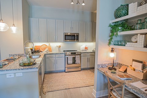 a kitchen with white cabinets and a counter top and a sink