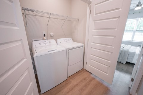 a washer and dryer in a room with a closet and a window