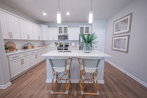 a kitchen with white cabinets and an island with bar stools