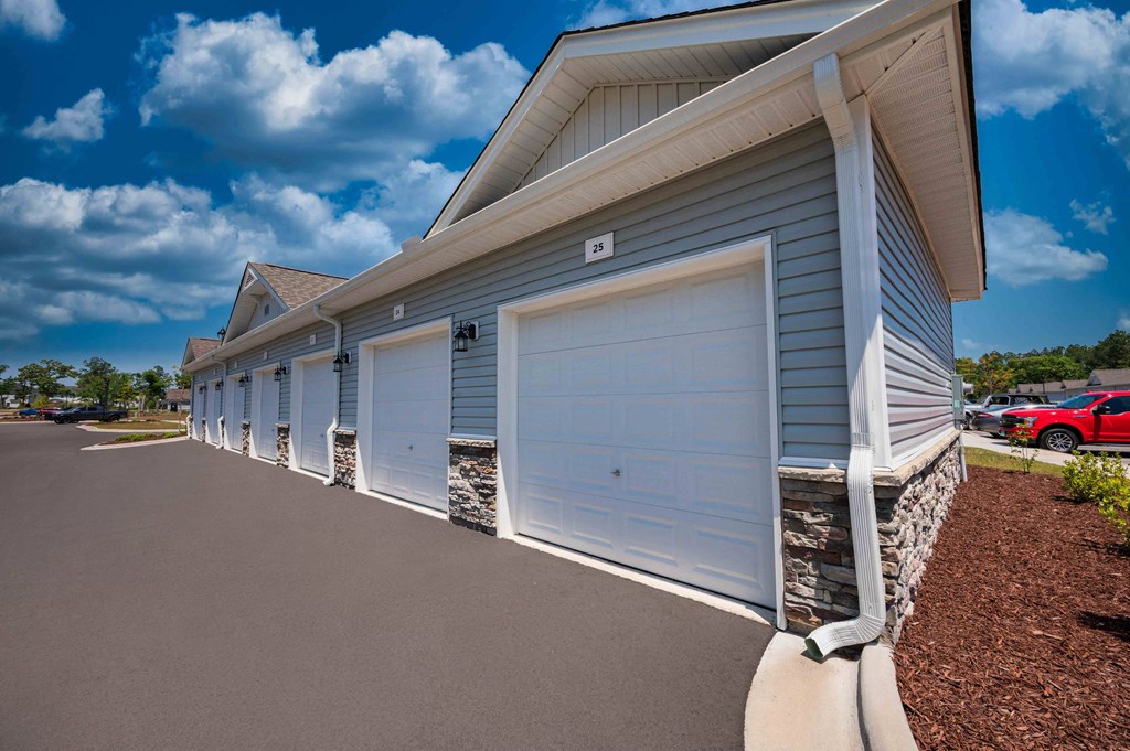 a row of white garage doors on the side of a building