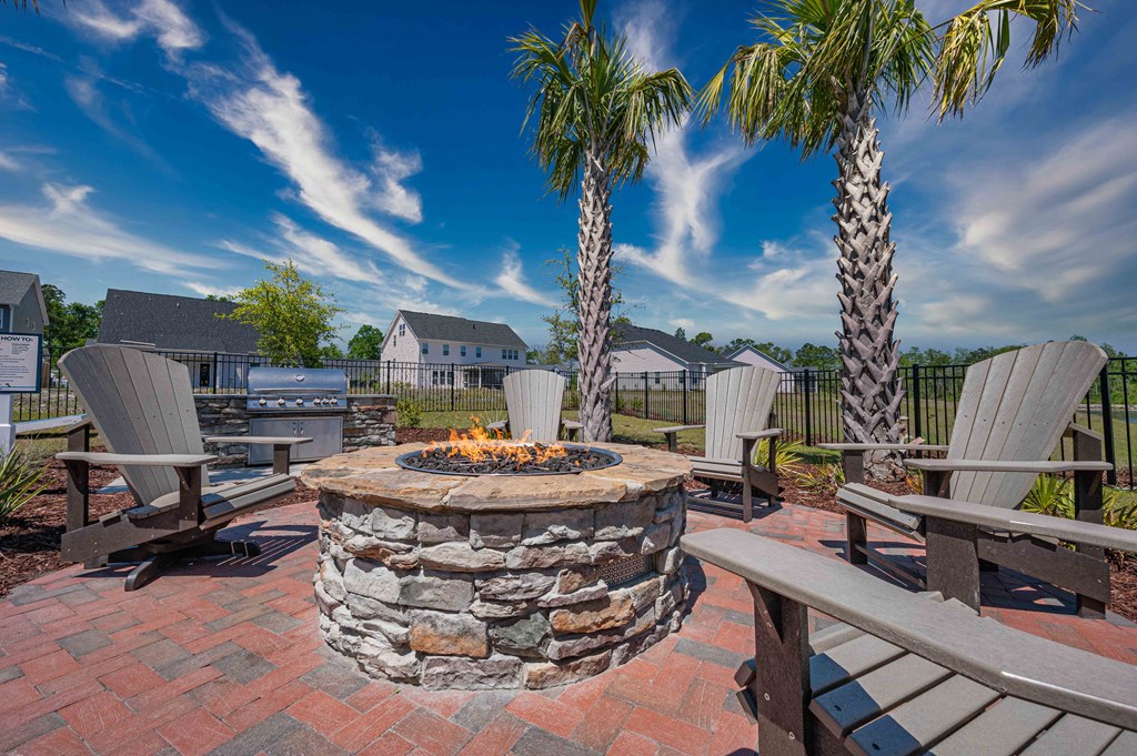 an outdoor patio with a fire pit and chairs