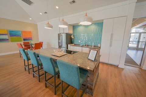 a kitchen with a long island with blue chairs