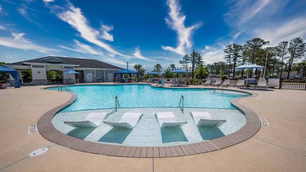Amenities A large outdoor swimming pool with a sun lounger area.