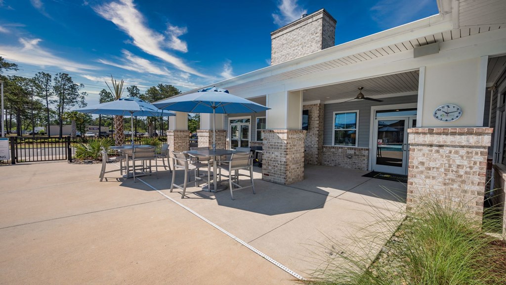 a patio with tables and umbrellas outside of a building
