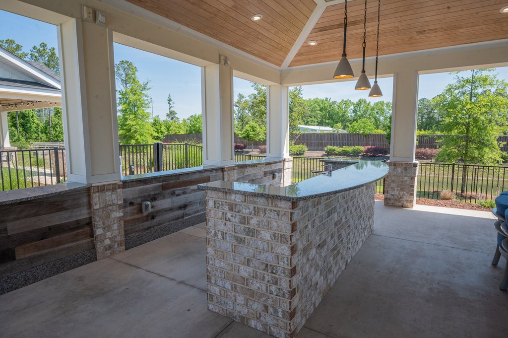 a covered patio with a bar in the center