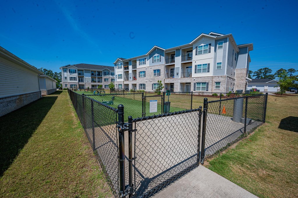 a fenced in yard with an apartment building in the background