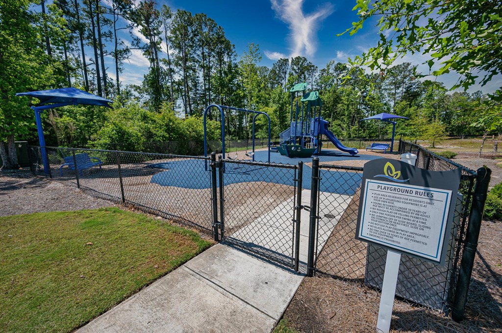 a park with a playground and a sign in front of it
