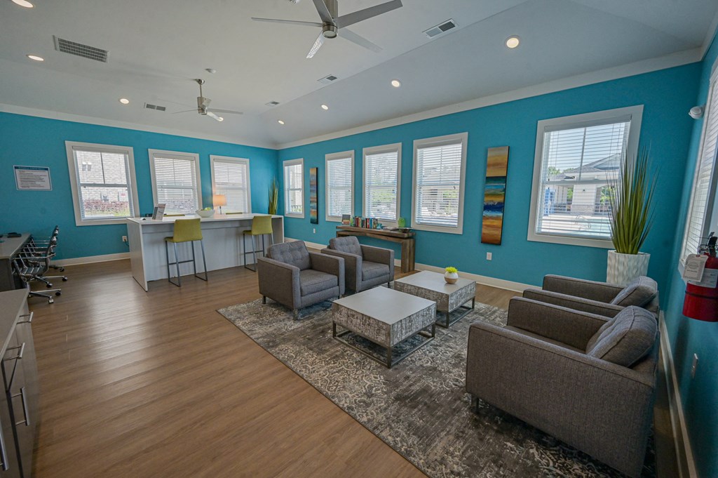 a living room with blue walls and couches and chairs