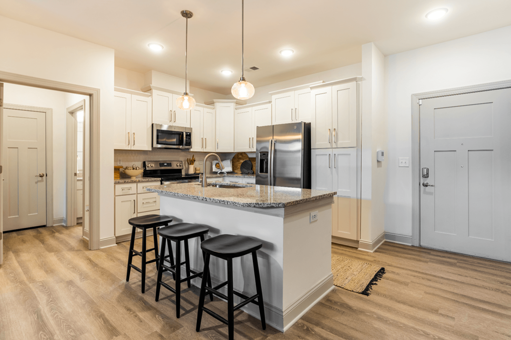 a kitchen with a large island with three stools