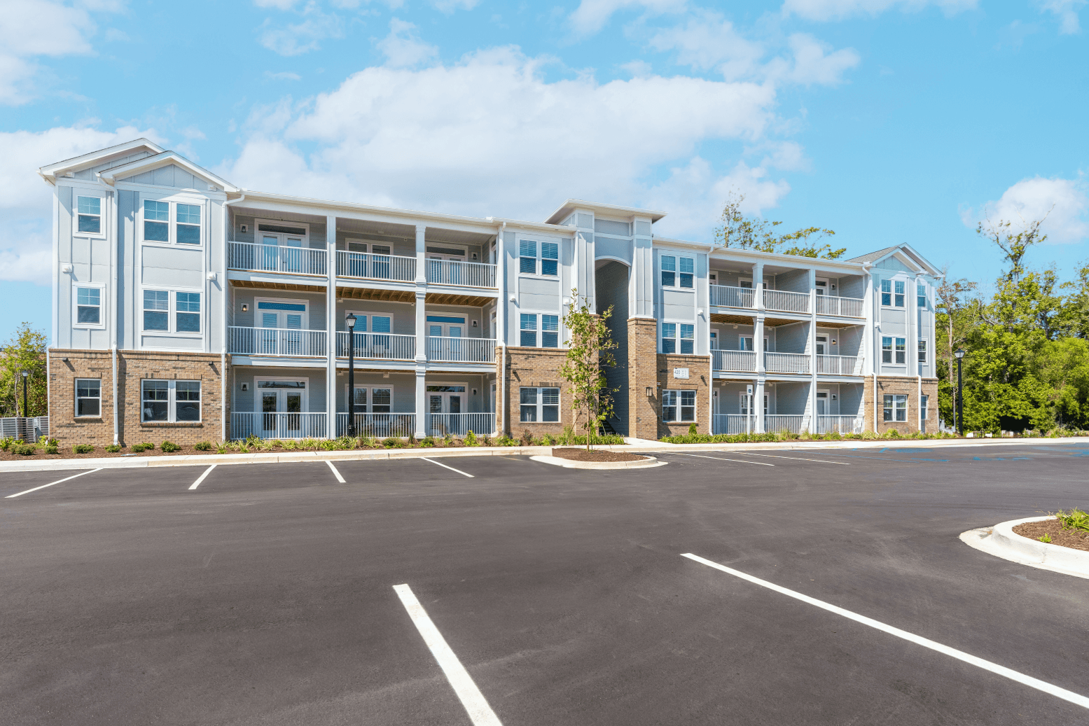 an empty parking lot in front of an apartment building