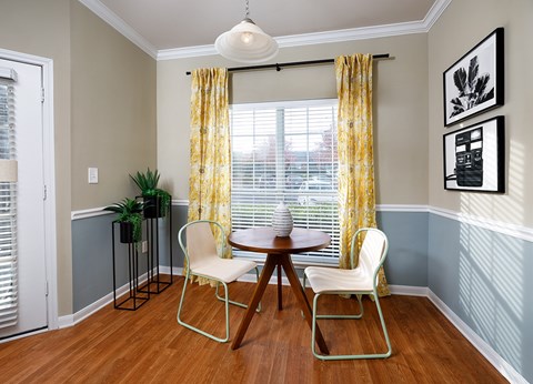 A dining room with a table and chairs.