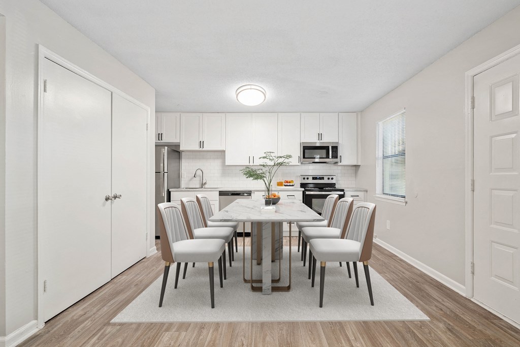 a dining room and kitchen with a table and chairs