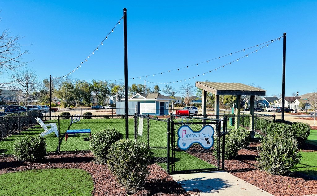 a park with a playground and a gated area with swings and a picnic area