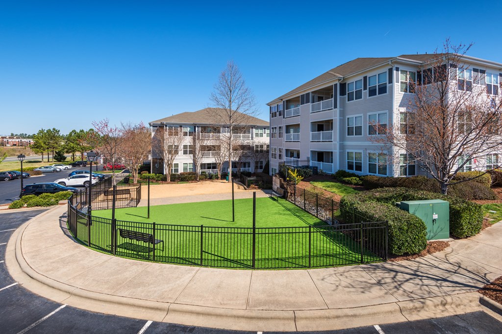 an image of an apartment building with a tennis court in front of it
