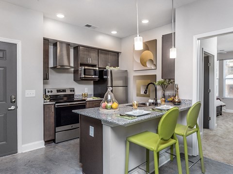 a kitchen with a bar and green stools