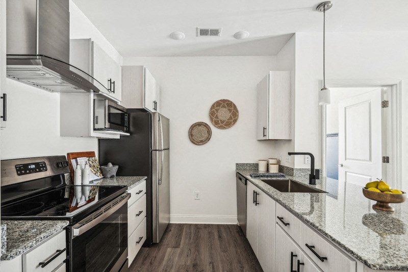 a modern kitchen with granite counter tops and stainless steel appliances