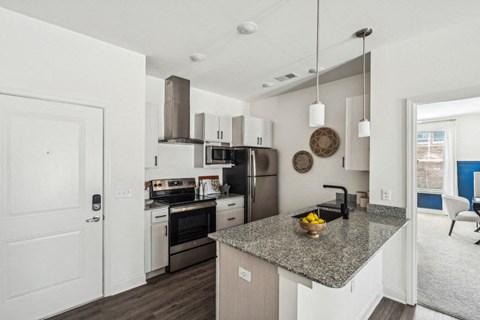 A kitchen with a granite countertop and stainless steel appliances.