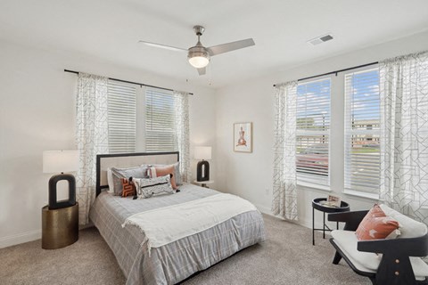 A bedroom with a large bed and a chair.
