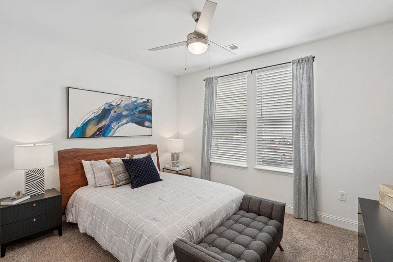 a bedroom with a bed and a large window
