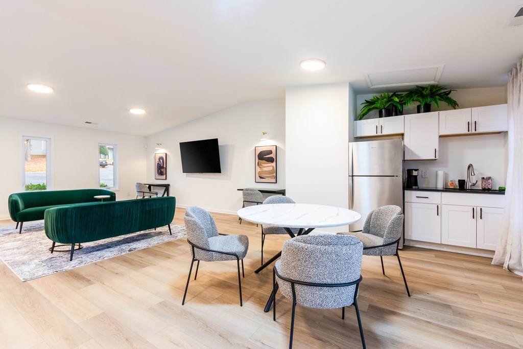 A modern living room with a green sofa and grey chairs.