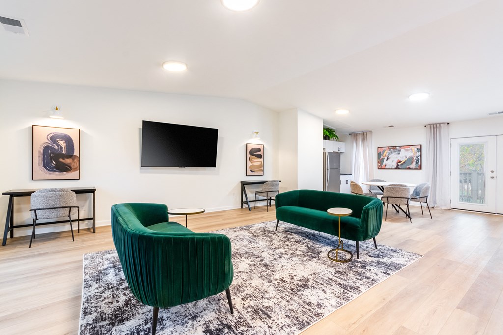 A living room with a green chair and a black television.