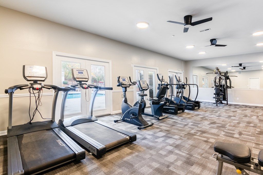 A spacious gym with treadmills, elliptical machines, and other exercise equipment.