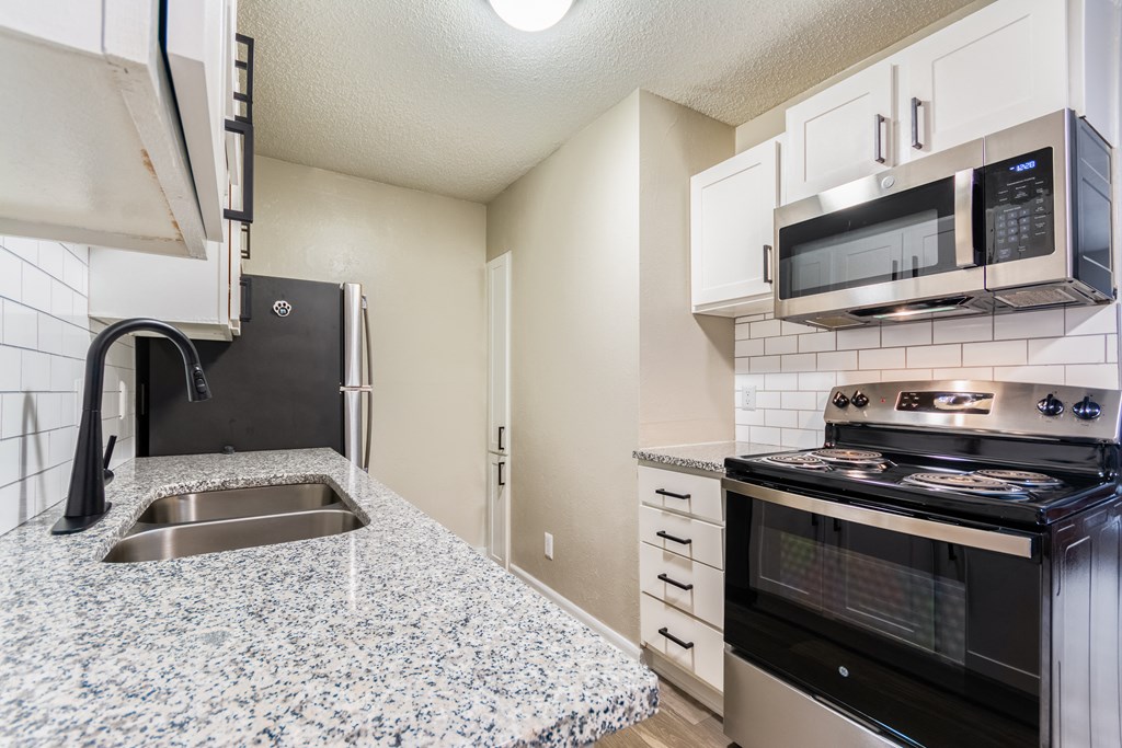 A kitchen with granite countertops and stainless steel appliances.