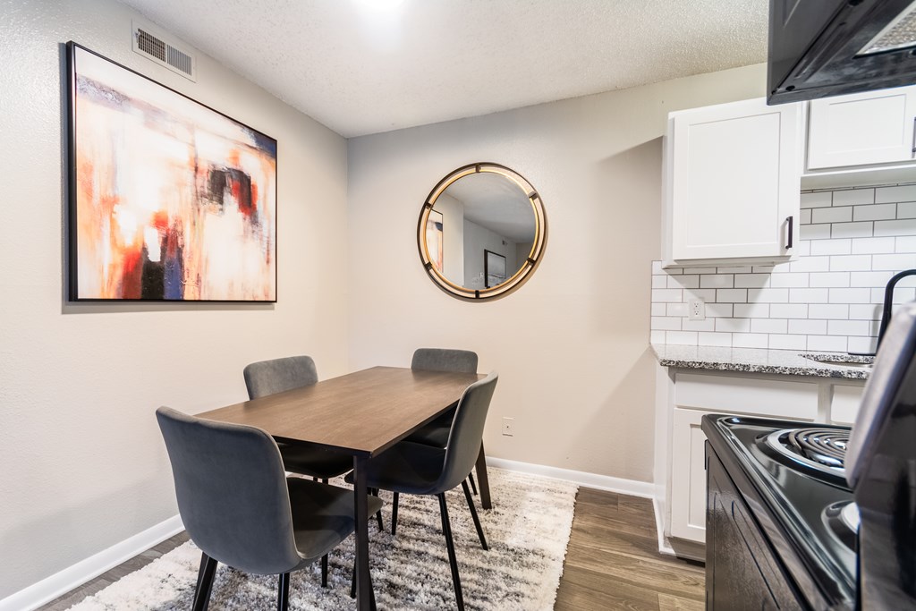 A dining room with a wooden table and chairs.