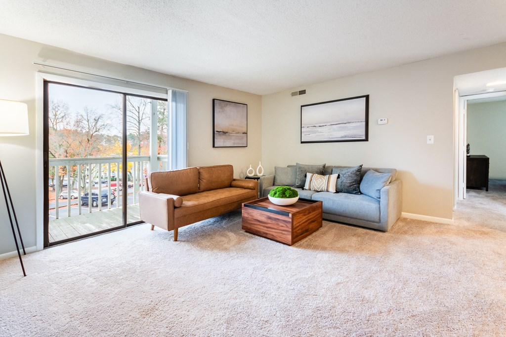 A living room with a couch, coffee table, and pictures on the wall.