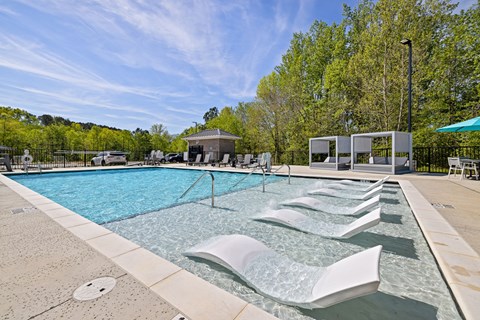 A pool with a fountain in the middle of it.